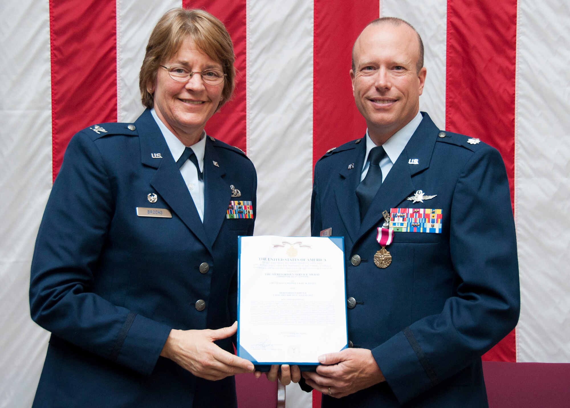 TRAVIS AIR FORCE BASE, Calif. -- Colonel Craig Wells, 349th Mission Support Group, receives the meritorious service medal and pins on the rank of Colonel during a pinning-on ceremony held here at Travis Air Force Base, Calif. on August 10, 2013. ( U.S Air Force photo / Senior Airman Amelia Leonard) 