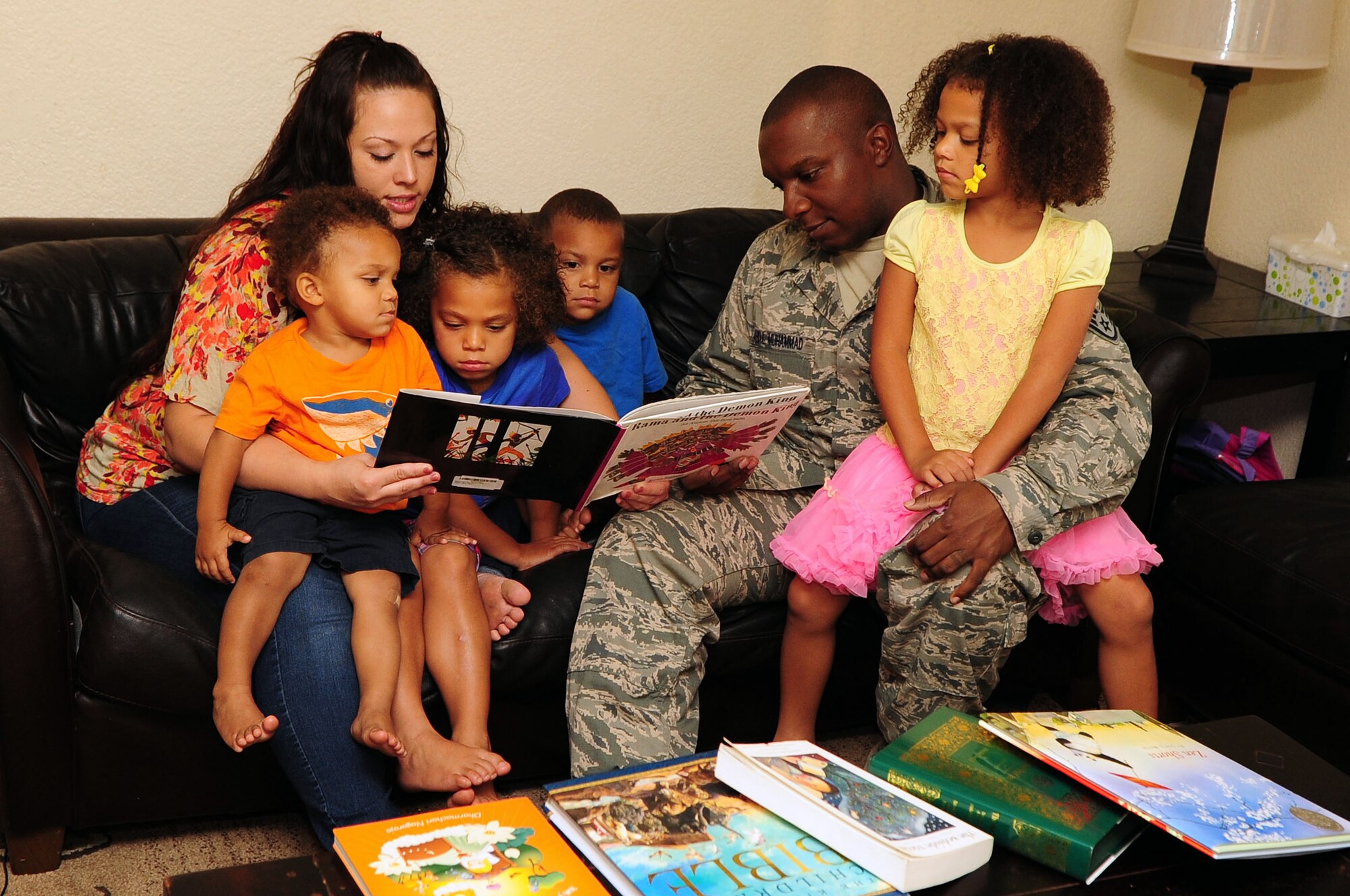 U.S. Air Force Staff Sgt. Asad Abdul Muhammad, 355th Fighter Wing protocol specialist, and his family sit down and read a book about religion at their home at Davis-Monthan Air Force Base, Ariz., Aug. 13, 2013. Abdul and his wife Ashley believe in allowing their children to pick their own religion. (U.S. Air Force photo by Senior Airman Camilla Elizeu/Released)