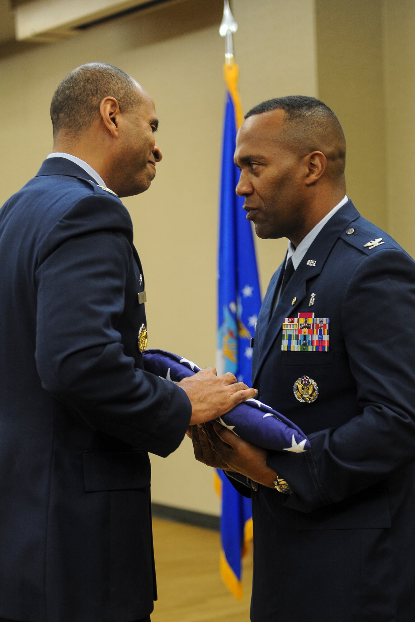 U.S. Air Force Col. Edward Ford, 23d Mission Support Group commander, presents a flag to Col. Alvis Headen III, 23d Medical Group commander, during a retirement ceremony Aug. 9, 2013, at Moody Air Force Base, Ga. Headen and Ford are good friends who were track and field competitors in high school. (U.S. Air Force photo by Airman Alexis A. Grotz/Released) 