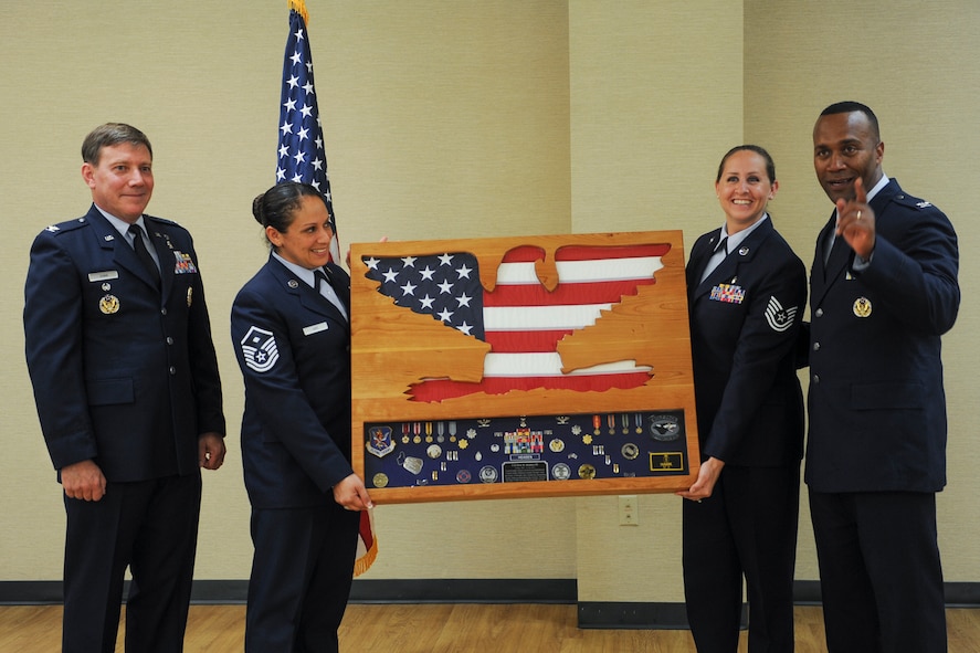 U.S. Air Force Col. Alvis Headen III (far right), 23d Medical Group commander, receives a shadow box from his unit during a retirement ceremony Aug. 9, 2013, at Moody Air Force Base, Ga. Shadow boxes are given to military members upon retirement and usually contain medals and awards the retiree earned throughout a career. (U.S. Air Force photo by Airman Alexis A. Grotz/Released)  