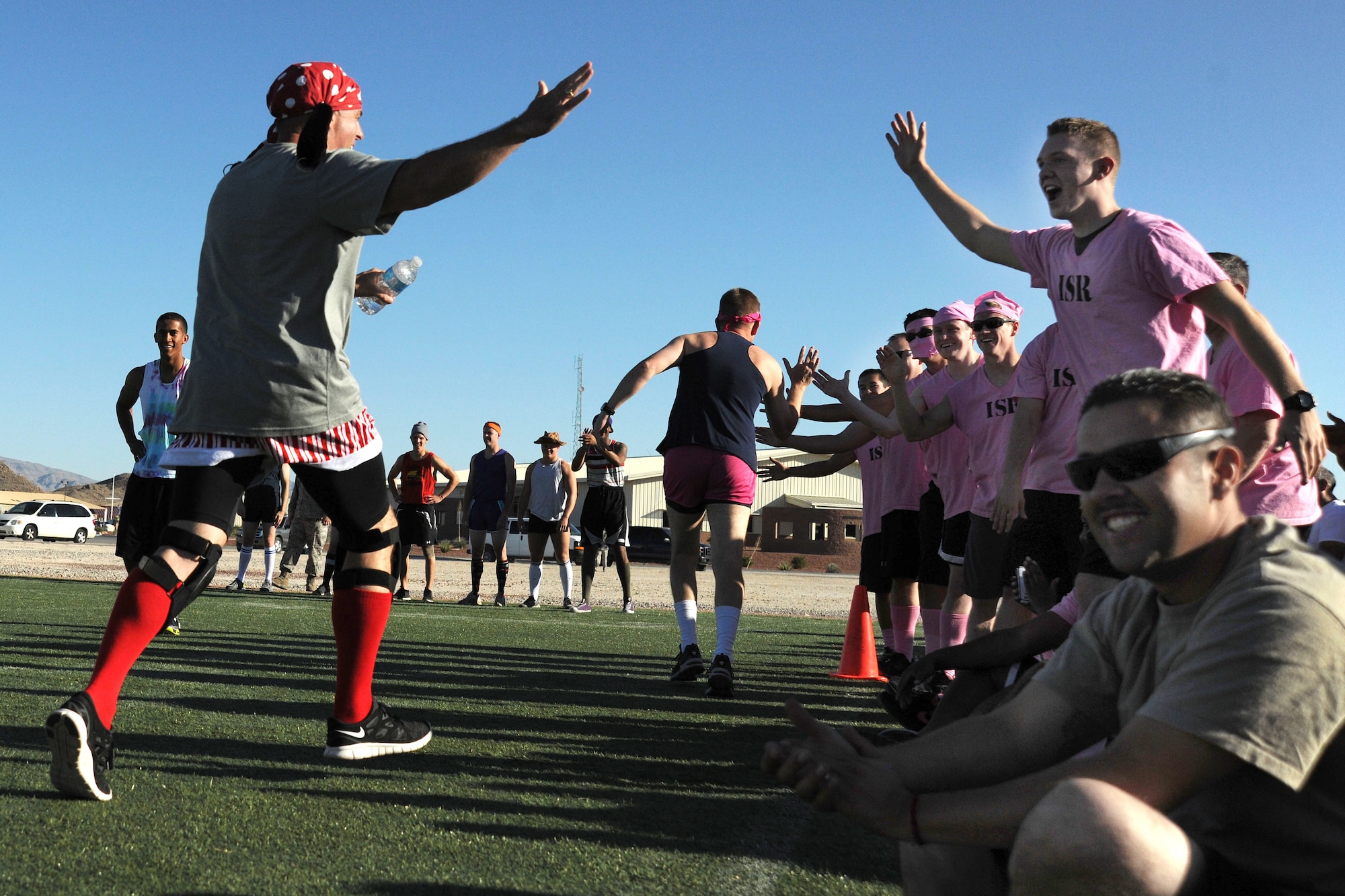 LAS VEGAS, Nev. -- Col. James Cluff (center), 432nd Wing/ 432nd Air Expeditionary Wing commander and Chief Master Sgt. Butch Brien, 432d WG/432d AEW command chief, give high fives to Airmen participating in the wing’s kickoff dodge ball tournament as part of the Comprehensive Airmen Fitness Day, Aug. 9, 2013. A total of 13 teams participated in the day’s event to strengthen understanding and application of CAF through interactive training and team-building activities. (U.S. Air Force photo by Staff Sgt. N.B./released)