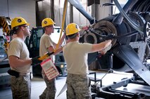 Staff Sgt. Eric Holtz, Airmen 1st Class Daniel Bombeck and Spencer Valentine, 934th Maintenance Squadron, work to remove the propeller from the engine of a retired C-130 aircraft at Minneapolis-St. Paul Air Reserve Station, Minn.  (U.S. Air Force photo/Shannon McKay)