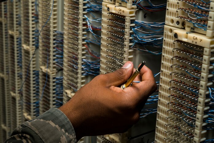 Staff Sgt. Spenser Amos, 628th Communications Squadron cyber transport systems technician, finds a new number location on a line equipment number block Aug. 8, 2013, at Joint Base Charleston - Air Base, S.C. The infrastructure flight maintains all communications cabling which includes copper wiring, inside building cabling, outside building cabling, all telephone switches to include two main systems on the Weapons Station and four main systems on the Air Base for voice systems, as well as a 400 device data network between both sides of the base for more than 200 buildings. (U.S. Air Force photo/ Senior Airman George Goslin)