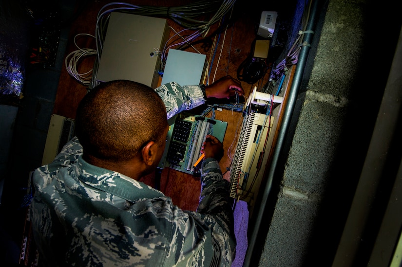 Staff Sgt. Spenser Amos, 628th Communications Squadron cyber transport systems technician, wires phone lines to a number block during a trouble ticket call Aug. 8, 2013, at Joint Base Charleston - Air Base, S.C. The infrastructure flight maintains all communications cabling which includes copper wiring, inside building cabling, outside building cabling, all telephone switches to include two main systems on the Weapons Station and four main systems on the Air Base for voice systems, as well as a 400 device data network between both sides of the base for more than 200 buildings. (U.S. Air Force photo/ Senior Airman George Goslin)