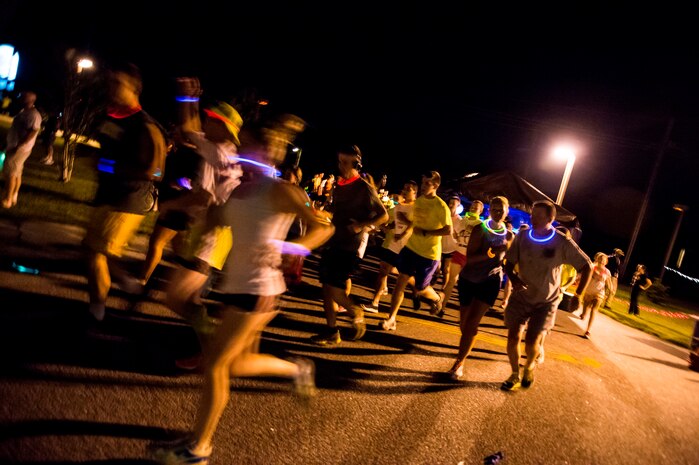 Service members and their families start the Nuclear Glow 5K Aug. 9, 2013, at Joint Base Charleston - Weapons Station, S.C. Service members and their families ran through base housing wearing glow-in-the-dark clothing and accessories.  (U.S. Air Force photo/ Senior Airman George Goslin)