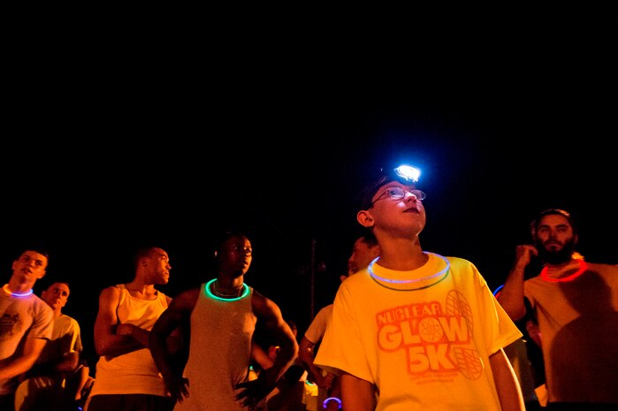 Jordan Cadiz, son of Adrian Cadiz, 1st Combat Camera Squadron non-commissioned-officer-in-charge of flying operations, prepares for the start of the Nuclear Glow 5K, Aug. 9, 2013, at Joint Base Charleston - Weapons Station, S.C. Competitors wore glow-in-the-dark clothing and accessories as they ran through base housing. (U.S. Air Force photo/ Senior Airman George Goslin)