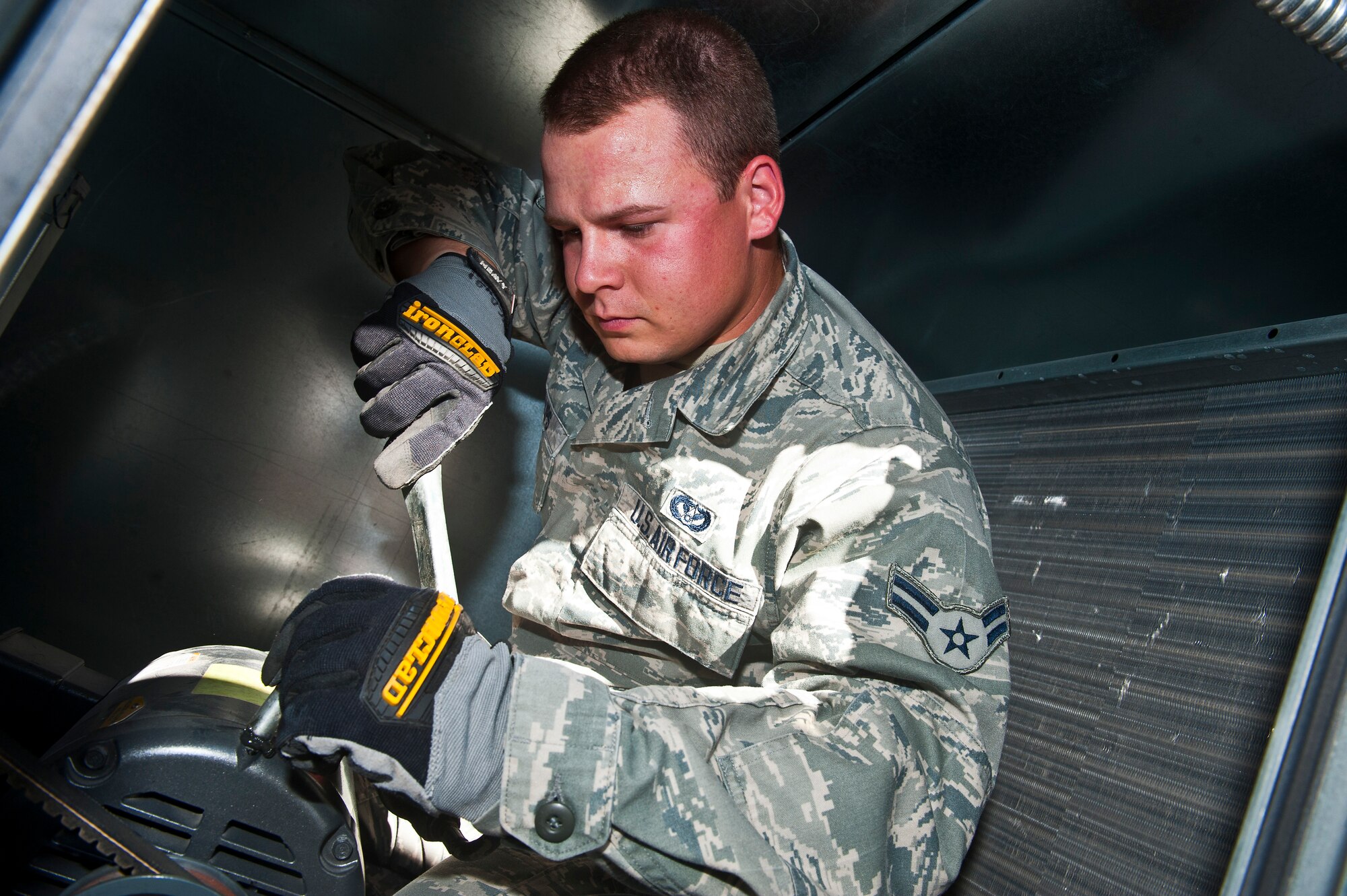 Airman 1st Class Joseph Phillips, 99th Civil Engineer Squadron heating, ventilation, air conditioning and refrigeration apprentice, adds oil lube to the motor of an air-handler unit at the 99th Logistics Readiness Squadron vehicle maintenance building Aug. 13, 2013, at Nellis Air Force Base, Nev. The oil provides lubrication to the motor to function properly. (U.S. Air Force photo/Senior Airman Brett Clashman)