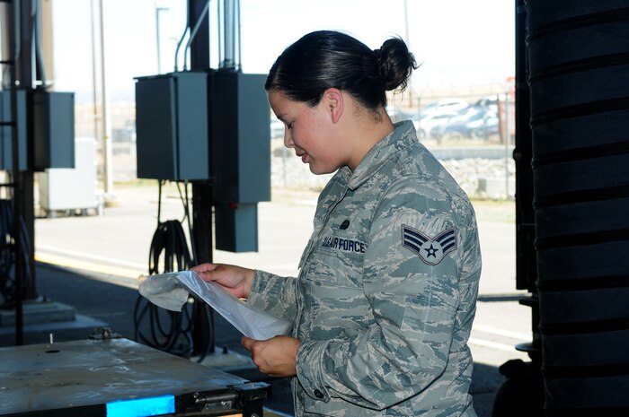 Senior Airman Yurina Zamora, 222nd Communications Maintenance Squadron radio frequency technician for the Global Hawk, reviews an H-VAC technical order before checking intake seals to the mission control elements at Beale Air Force Base, Calif., Aug. 13, 2013. Zamora is competing for the 22nd CMXS Airman of the Year award. (U.S. Air Force photo by Senior Airman Allen Pollard/Released)