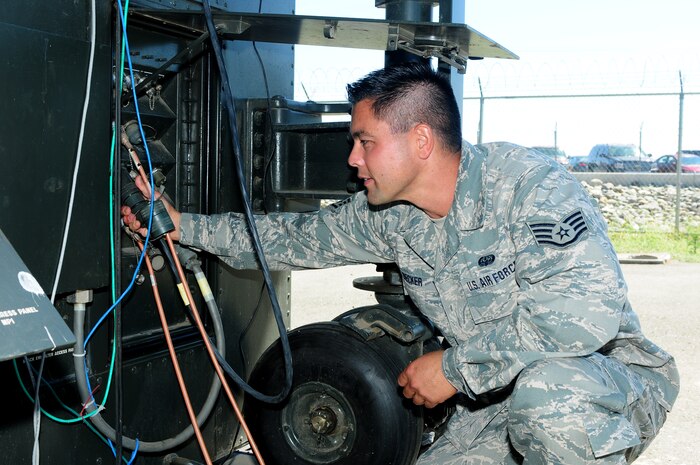 Staff Sgt. Forest Decker, 222nd Communications Maintenance Squadron cyber transport technician, checks power connections to a mission control element at Beale Air Force Base, Calif., Aug. 13, 2013. The MCE uses a tactical field terminal antenna to communicate with the aircraft. (U.S. Air Force photo by Senior Airman Allen Pollard/Released)