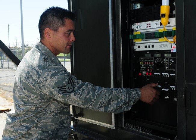 Staff Sgt. Forest Decker, 222nd Communications Maintenance Squadron cyber transport technician, powers up a tactical field terminal antenna at Beale Air Force Base, Calif., Aug. 13, 2013. Decker is competing for the 222nd CMXS NCO of the Year award. (U.S. Air Force photo by Senior Airman Allen Pollard/Released)