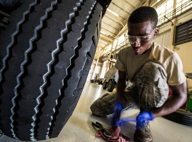 Airman 1st Class Charles Cannon, 437th Maintenance Squadron Aerospace Ground Equipment technician, wipes grease off of his gloves and tools after reinstalling a wheel Aug. 6, 2013, at Joint Base Charleston – Air Base, S.C. The process of cleaning and reattaching a wheel bearing takes a technician approximately 25 to 30 minutes. (U.S. Air Force photo/ Senior Airman Dennis Sloan)