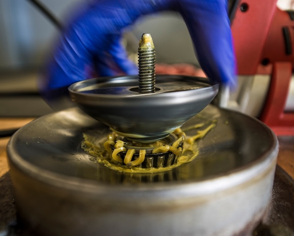 Airman 1st Class Charles Cannon, 437th Maintenance Squadron Aerospace Ground Equipment technician, removes a clamp from a wheel bearing part after applying grease Aug. 6, 2013, at Joint Base Charleston – Air Base, S.C. (U.S. Air Force photo/ Senior Airman Dennis Sloan)