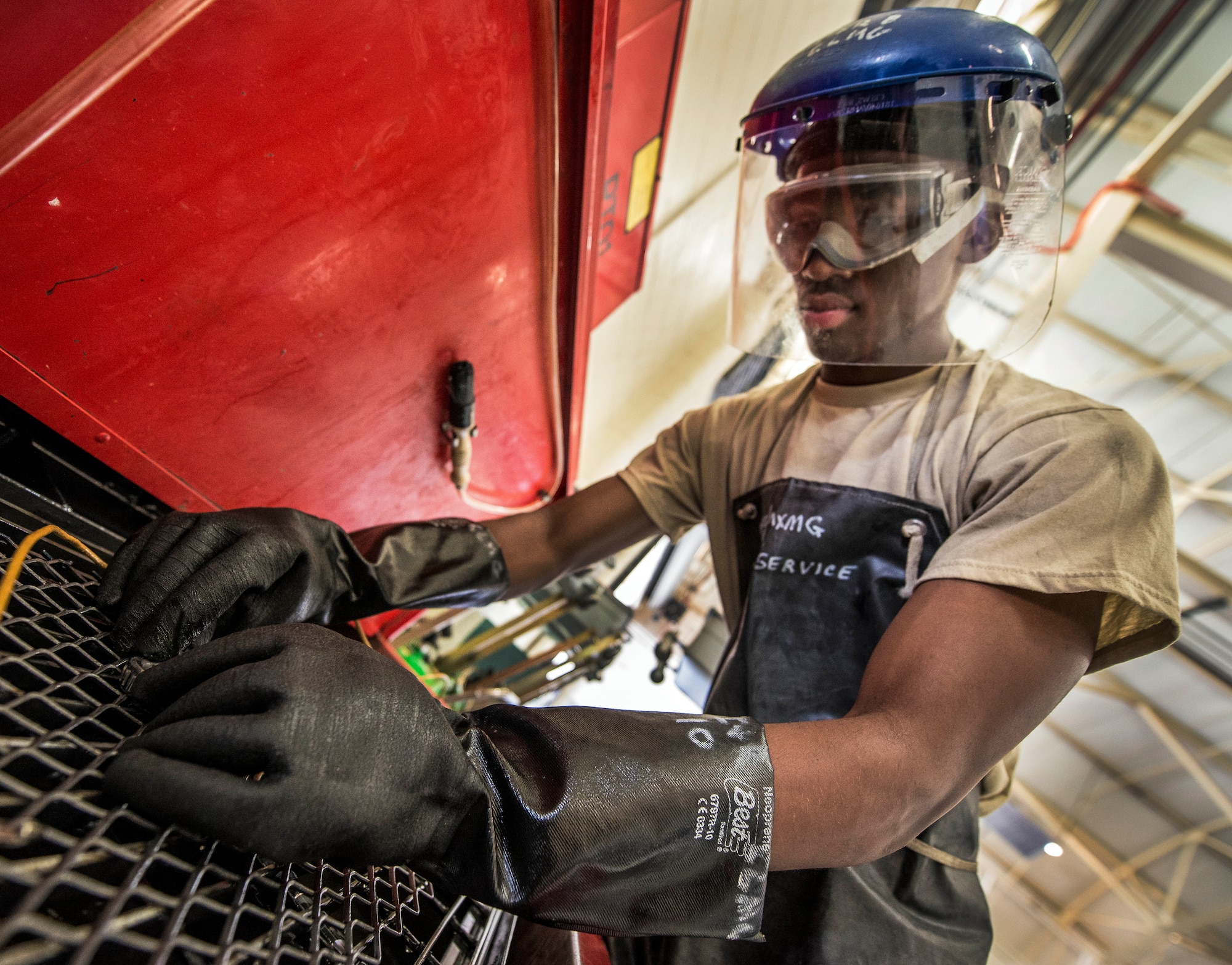 Airman 1st Class Charles Cannon, 437th Maintenance Squadron Aerospace Ground Equipment technician, cleans wheel bearing parts in a chemical bath to remove old grease Aug. 6, 2013, at Joint Base Charleston – Air Base, S.C. Once the bearings have gone through the chemical bath, they are scrubbed with a brush to remove all traces of grease. (U.S. Air Force photo/ Senior Airman Dennis Sloan)