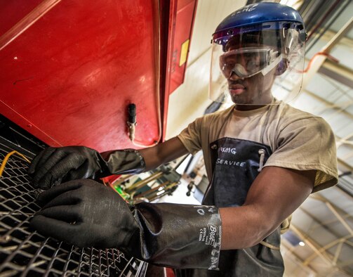 Airman 1st Class Charles Cannon, 437th Maintenance Squadron Aerospace Ground Equipment technician, cleans wheel bearing parts in a chemical bath to remove old grease Aug. 6, 2013, at Joint Base Charleston – Air Base, S.C. Once the bearings have gone through the chemical bath, they are scrubbed with a brush to remove all traces of grease. (U.S. Air Force photo/Senior Airman Dennis Sloan) 

