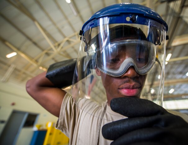 Airman 1st Class Charles Cannon, 437th Maintenance Squadron Aerospace Ground Equipment technician, puts a face shield over his goggles for protection from the chemicals used to clean wheel bearing parts Aug. 6, 2013, at Joint Base Charleston – Air Base, S.C. Once the bearings have gone through the chemical bath, they are scrubbed with a brush to remove all traces of grease. (U.S. Air Force photo/ Senior Airman Dennis Sloan)