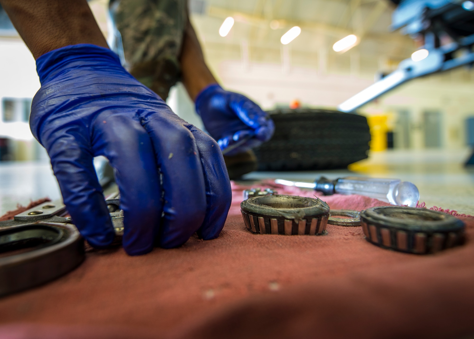 Airman 1st Class Charles Cannon, 437th Maintenance Squadron Aerospace Ground Equipment technician, places wheel bearing parts on a rag to inspect and clean Aug. 6, 2013, at Joint Base Charleston – Air Base, S.C. Cannon removed all the old grease from the bearing and placed the parts in a special washing machine that uses a chemical solvent to remove all the grease. (U.S. Air Force photo/ Senior Airman Dennis Sloan)