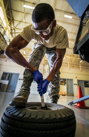 Airman 1st Class Charles Cannon, 437th Maintenance Squadron Aerospace Ground Equipment technician, pries a wheel bearing out of a wheel assembly of a floodlight vehicle Aug. 6, 2013, at Joint Base Charleston – Air Base, S.C. The floodlight vehicle is used by maintainers on the flightline at night or in low-light areas while they perform maintenance on C-17 Globemaster III’s. (U.S. Air Force photo/ Senior Airman Dennis Sloan)