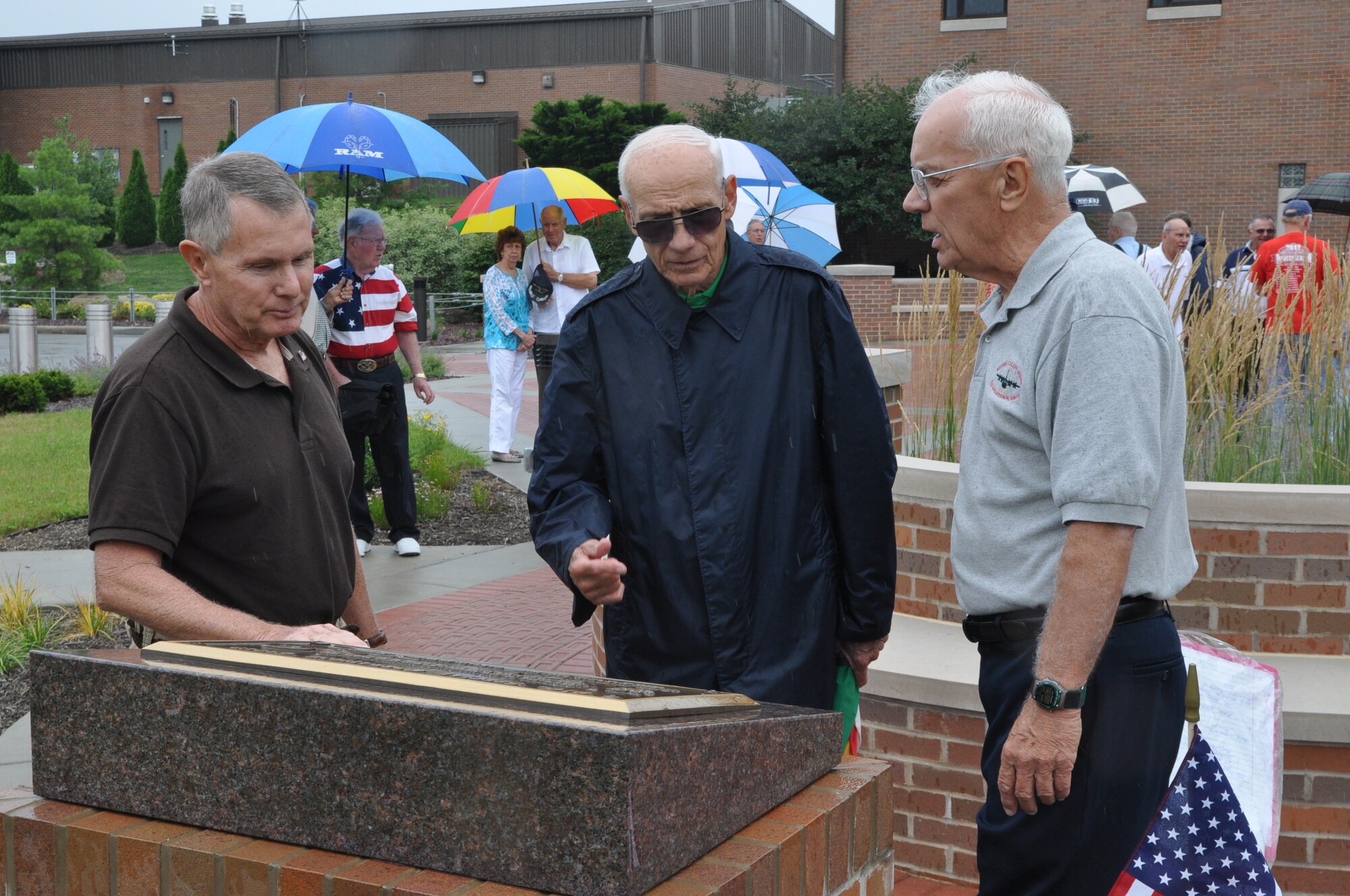 YOUNGSTOWN AIR RESERVE STATION, Ohio -- Don Piltz, former captain and pilot with the 757th Fighter Squadron (FS) and 757th Tactical Airlift Squadron (TAS); Retired Maj. Gen. Donald Jenkins, former commander of the 757th Troop Carrier Squadron and retired Chief Master Sgt. Norm Vasil, former C-119 loadmaster and Senior Enlisted Advisor for the 757th TAS stand and talk next to a memorial marker here after a ceremony honoring fallen members of the heritage units of the 757th Airlift Squadron, July 27, 2013. The memorial marker is located near the 910th Airlift Wing headquarters building flagpole. The men are all members of the 757th Veteran’s Association, which hosted the ceremony and is celebrating its 30th anniversary this year.