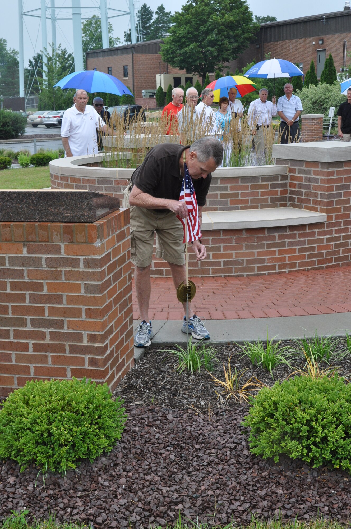 YOUNGSTOWN AIR RESERVE STATION, Ohio -- Don Piltz, a former captain and pilot with the 757th Fighter Squadron and 757th Tactical Airlift Squadron, places a flag near a memorial marker here during a ceremony honoring fallen members of the heritage units of the 757th Airlift Squadron, July 27, 2013. The memorial marker is located near the 910th Airlift Wing headquarters building flagpole. Piltz is a member of the 757th Veteran’s Association, which hosted the ceremony and is celebrating its 30th anniversary this year.
