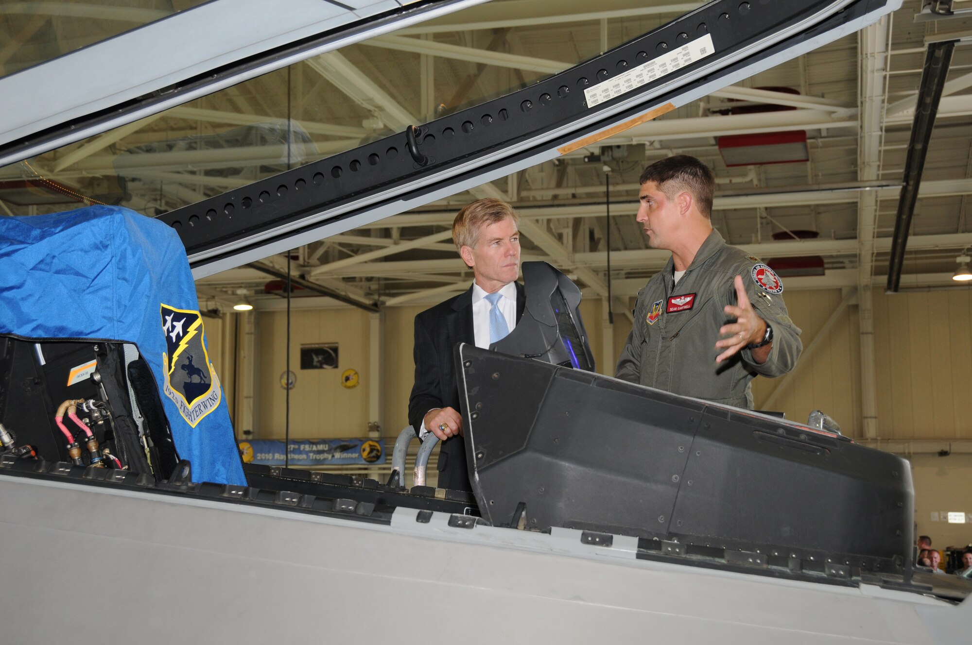 Governor Bob McDonnell receives a brief on the cockpit controls and capabilities of the F-22 Raptor from Maj. Sean Cantwell, Virginia Air National Guard, F-22 fighter pilot at Joint Base Langley-Eustis, August 13, 2013, during his "This Commonwealth of Opportunity" statewide tour. Following his mission briefing on the F-22, the governor visited the 192d Intelligence Squadron and received a mission briefing on the Distributed Ground System capabilities.  (U.S. Air National Guard photo by Master Sgt. Carlos J. Claudio/Released).