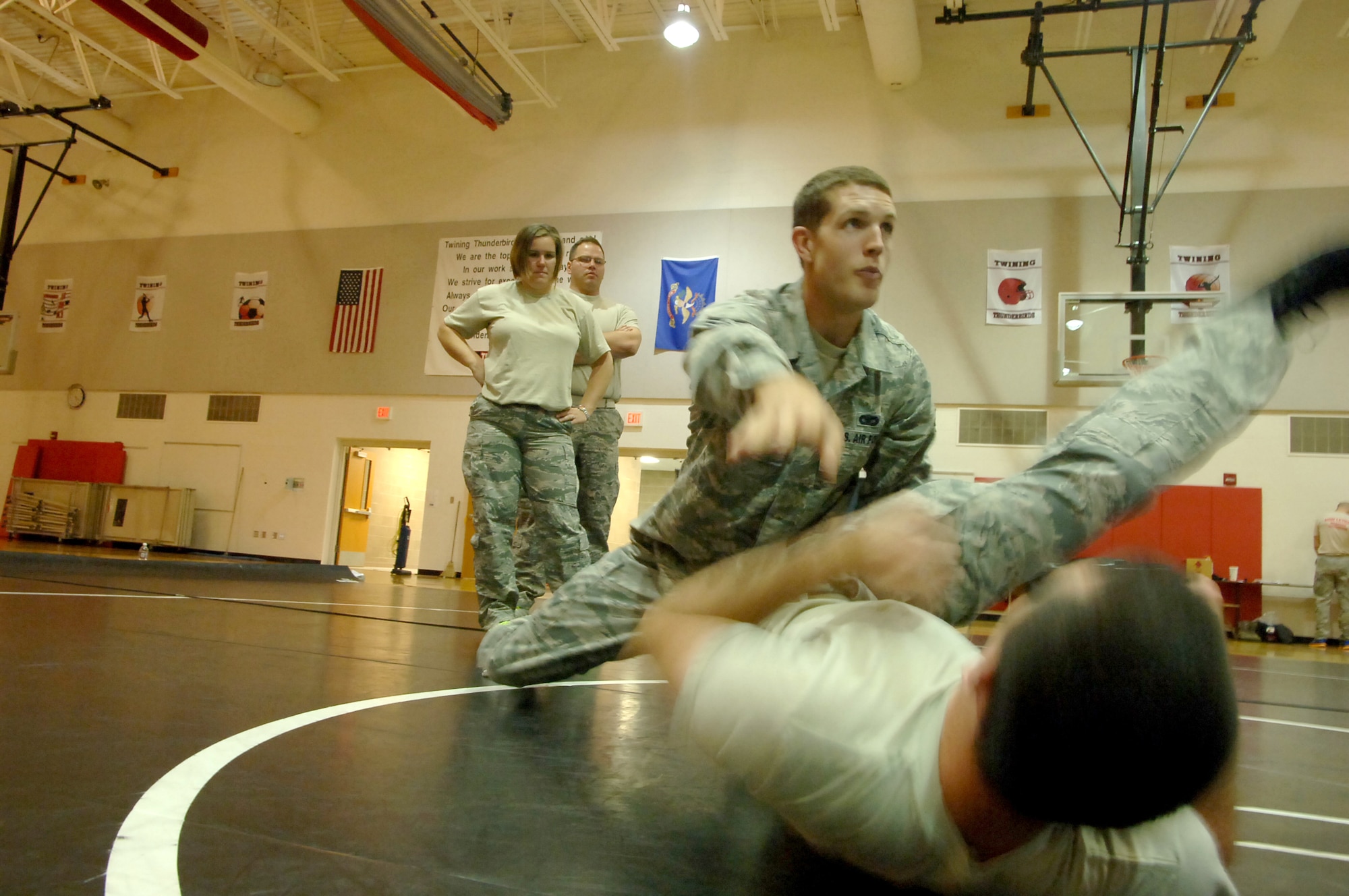 Senior Airman Cody Lowe demonstrates how to avoid a strike and break out of a submissive hold while using a sweeping leg maneuver  during a during a mixed martial arts basic ground combat training session, which he instructed  Aug. 13, 2013, at the Gen. Nathan F. Twining Elementary Gymnasium on Grand Forks Air Force Base, N.D.  The 319th Security Forces Squadron member from Hartford, S.D., was named the base’s Warrior of the Week for the third week of August. (U.S. Air Force photo/Staff Sgt. Luis Loza Gutierrez) 
