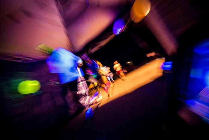 Service members and their families run through a tent with ultraviolet lights and glow-in-the-dark decorations during the Nuclear Glow 5K Aug. 9, 2013, at Joint Base Charleston – Weapons Station, S.C. The race was hosted by the 628th Force Support Squadron to promote fitness. (U.S. Air Force photo/ Senior Airman Dennis Sloan)