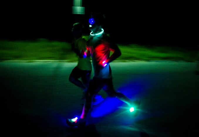 Service members and their families run through base housing wearing glow-in-the-dark clothing and accessories during the Nuclear Glow 5K Aug. 9, 2013, at Joint Base Charleston – Weapons Station, S.C. The race was hosted by the 628th Force Support Squadron to promote fitness. (U.S. Air Force photo/ Senior Airman Dennis Sloan)