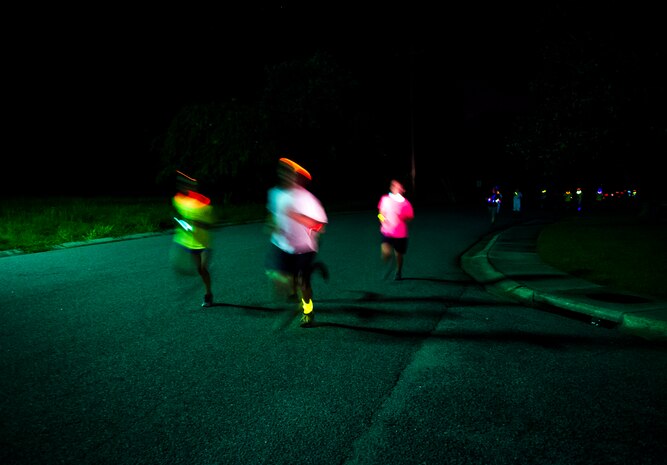 Service members and their families run through base housing wearing glow-in-the-dark clothing and accessories during the Nuclear Glow 5K Aug. 9, 2013, at Joint Base Charleston – Weapons Station, S.C. The race was hosted by the 628th Force Support Squadron. (U.S. Air Force photo/ Senior Airman Dennis Sloan)