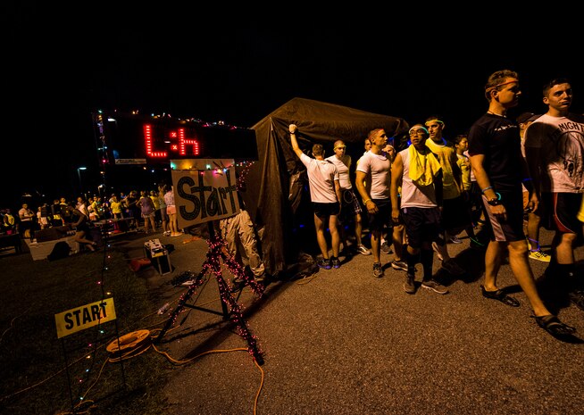 Service members and their families gather at the starting line of the Nuclear Glow 5K Aug. 9, 2013, at Joint Base Charleston – Weapons Station, S.C. Service members and their families ran through base housing wearing glow-in-the-dark clothing and accessories. (U.S. Air Force photo/ Senior Airman Dennis Sloan)