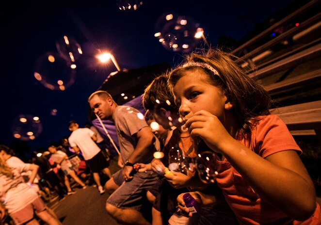 Petty Officer 1st Class Taylor Craig’s children Sidney, age 6, Rhyder, age 9, and Max, age 5, blow bubbles before the start of the Nuclear Glow 5K Aug. 9, 2013, at Joint Base Charleston – Weapons Station, S.C. Service members and their families ran through base housing wearing glow-in-the-dark clothing and accessories. Craig is assigned to the Naval Consolidated Brig Charleston. (U.S. Air Force photo/ Senior Airman Dennis Sloan)