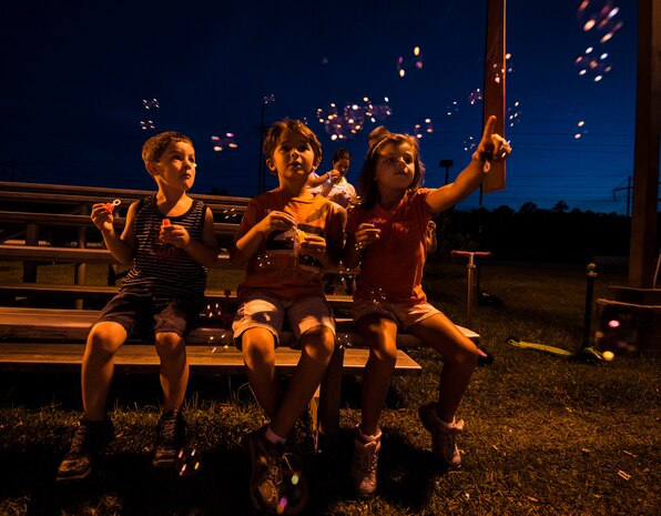 Petty Officer 1st Class Taylor Craig’s children Max, age 5, Rhyder, age 9, and Sidney, age 6, blow bubbles before the start of the Nuclear Glow 5K Aug. 9, 2013, at Joint Base Charleston – Weapons Station, S.C. Service members and their families ran through base housing wearing glow-in-the-dark clothing and accessories. Craig is assigned to the Naval Consolidated Brig Charleston.  (U.S. Air Force photo/ Senior Airman Dennis Sloan)