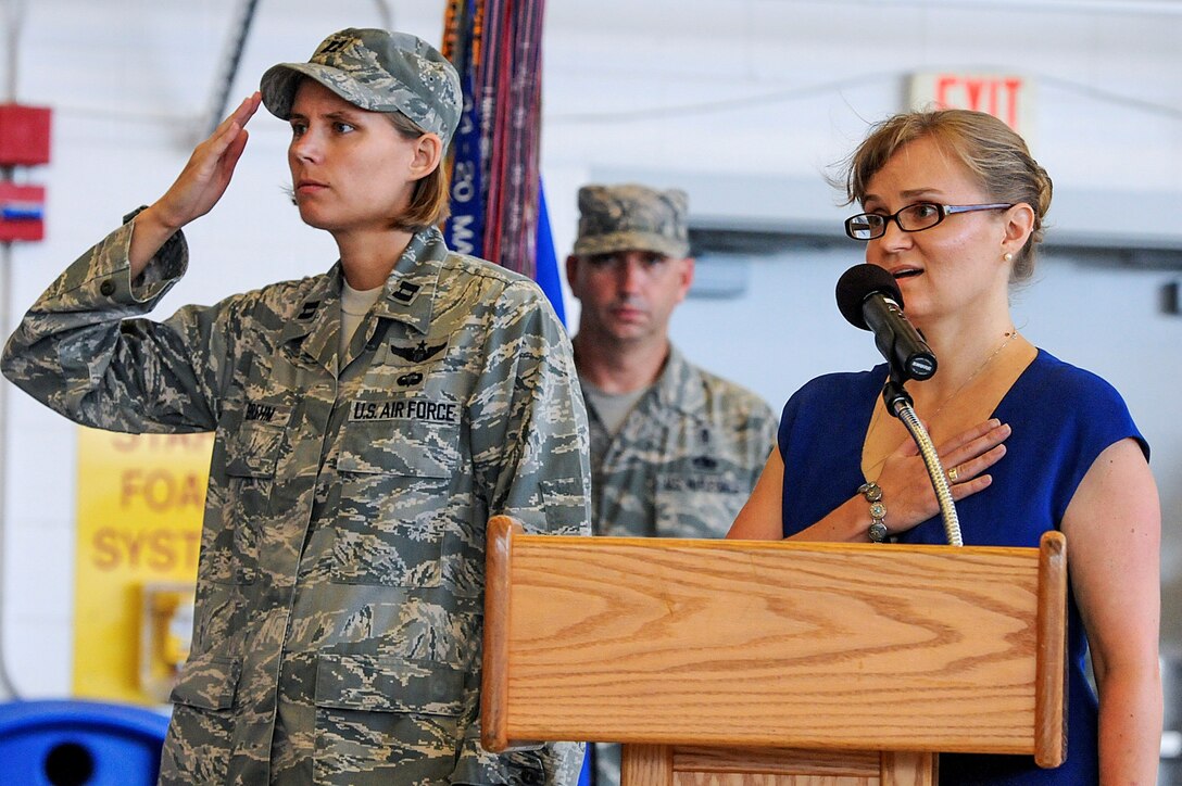 Susan Cotten, commander's secretary of 1st Special Operations Wing, right,
sings the national anthem, as Capt. Sarah Brehm, commander's executive of
1st SOW, left, and Chief Master Sgt. Jeffrey Maberry, command chief of 1st
SOW, center, renders military honors during the 1st SOW change of command
ceremony at the Freedom Hangar at Hurlburt Field, Fla., July 3, 2013. Col.
William West, former commander of 27th Special Operations Group, Cannon Air
Force Base, N.M., assumed command of the wing from outgoing commander, Col.
Jim Slife. (U.S. Air Force photo / Airman 1st Class Christopher Callaway)