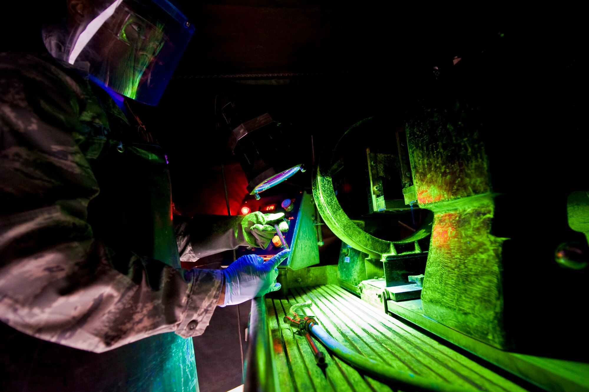 Senior Airman Darnell McConnell inspects an aircraft part for cracks by means of a magnetic particle inspection at the 379th Air Expeditionary Wing in Southwest Asia, Aug. 6, 2013. MPI is a nondestructive inspection process for detecting surface and slightly subsurface discontinuities in materials such as iron, nickel and cobalt. McConnell is a 379th Expeditionary Maintenance Squadron NDI journeyman deployed and hails from Colorado Springs, Colo. (U.S. Air Force photo/Senior Airman Benjamin Stratton)