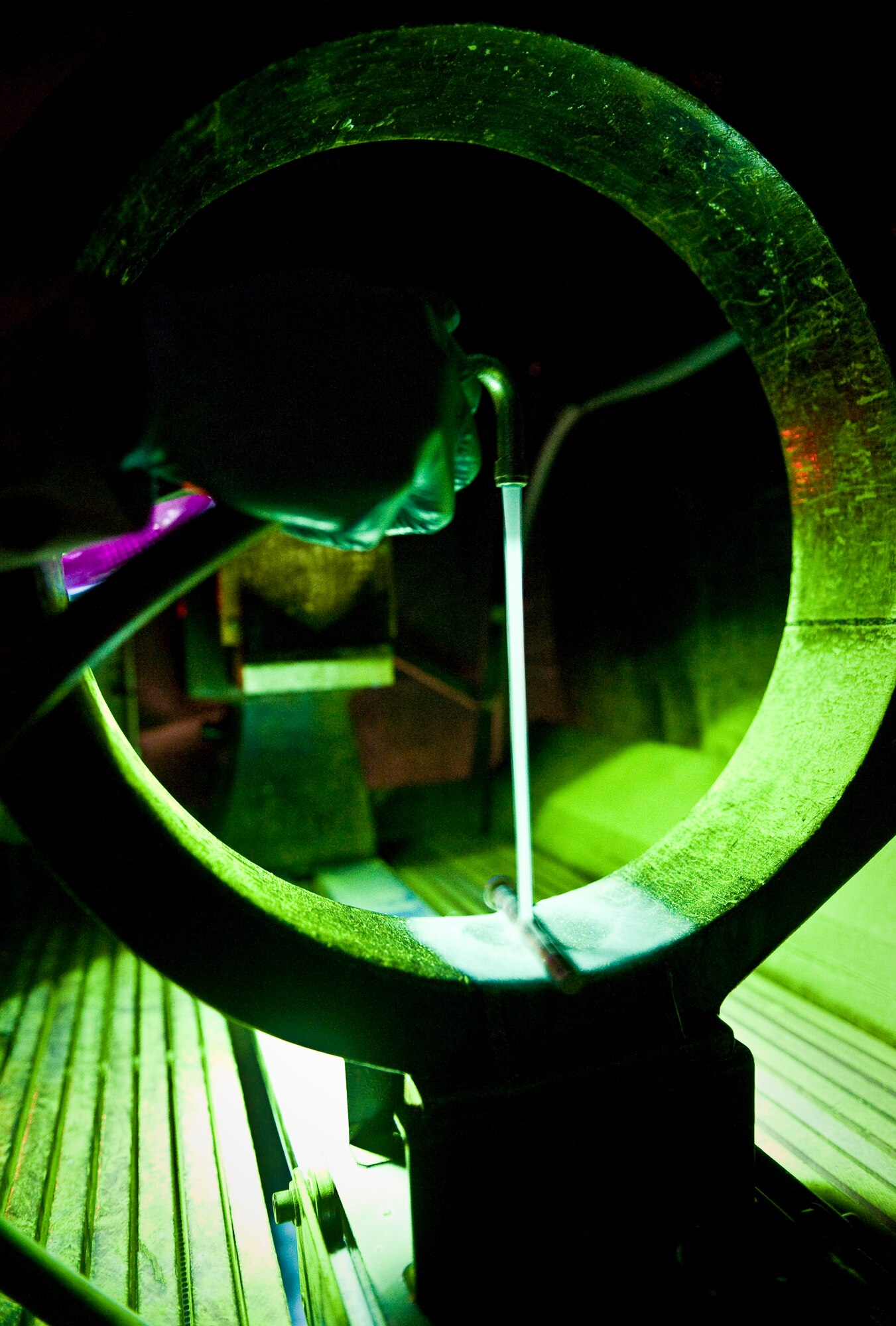 Senior Airman Darnell McConnell inspects an aircraft part for cracks by means of a magnetic particle inspection at the 379th Air Expeditionary Wing in Southwest Asia, Aug. 6, 2013. MPI is a nondestructive inspection process for detecting surface and slightly subsurface discontinuities in materials such as iron, nickel and cobalt. McConnell is a 379th Expeditionary Maintenance Squadron NDI journeyman deployed and hails from Colorado Springs, Colo. (U.S. Air Force photo/Senior Airman Benjamin Stratton)