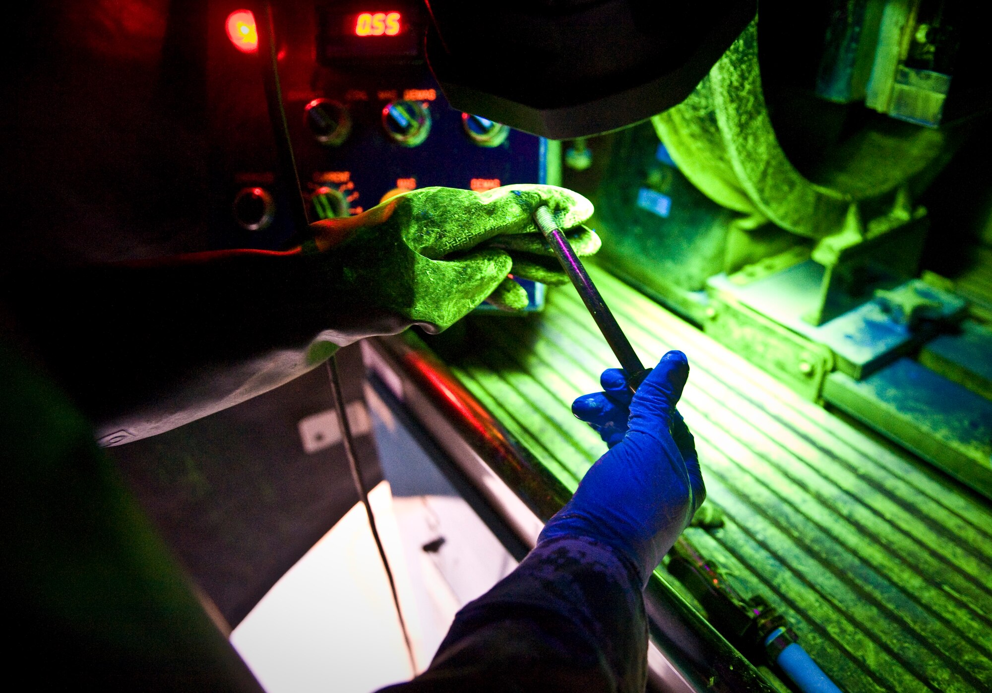 Senior Airman Darnell McConnell inspects an aircraft part for cracks by means of a magnetic particle inspection at the 379th Air Expeditionary Wing in Southwest Asia, Aug. 6, 2013. MPI is a nondestructive inspection process for detecting surface and slightly subsurface discontinuities in materials such as iron, nickel and cobalt. McConnell is a 379th Expeditionary Maintenance Squadron NDI journeyman deployed and hails from Colorado Springs, Colo. (U.S. Air Force photo/Senior Airman Benjamin Stratton)