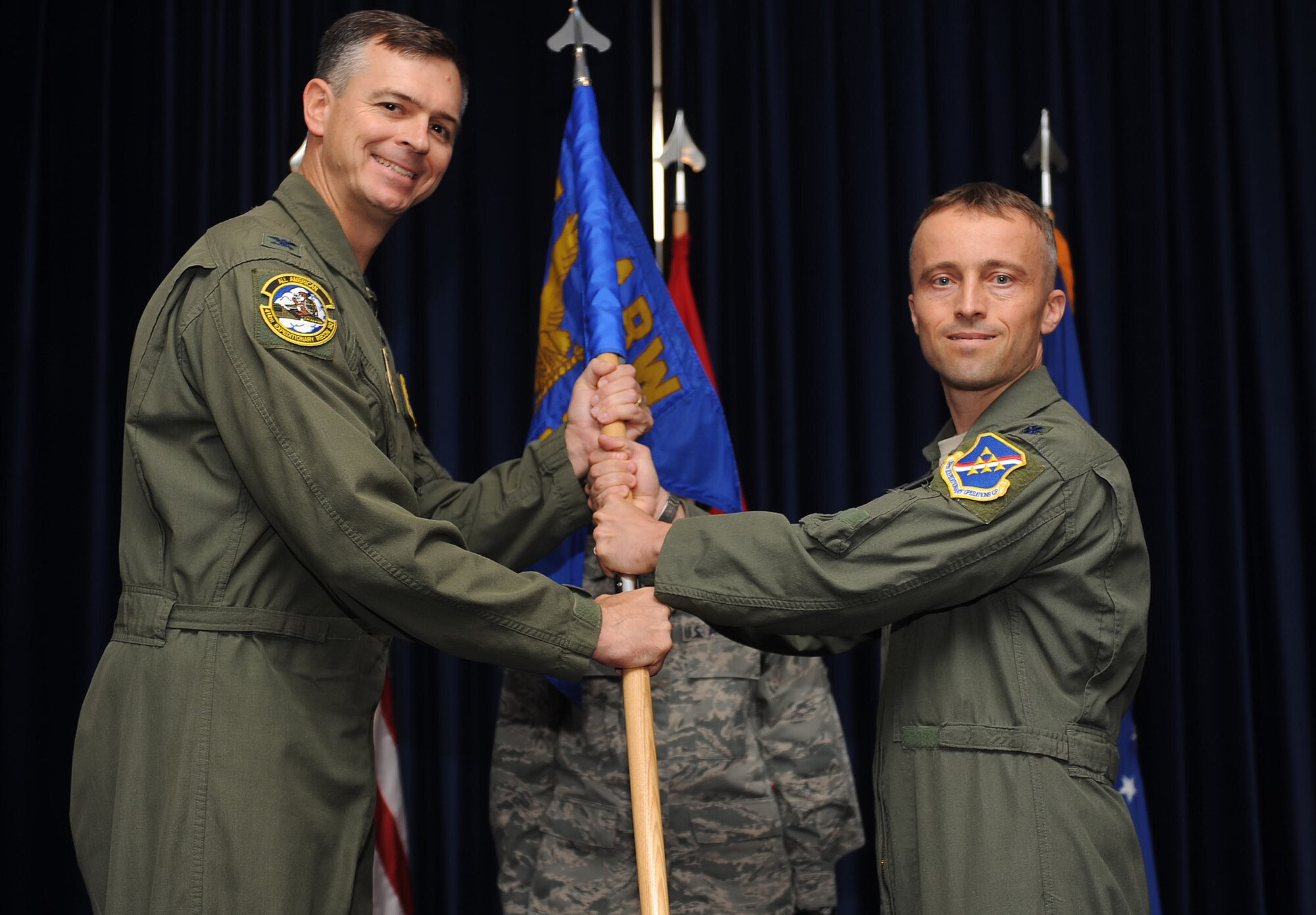 Lt. Col. Christopher Voehl, incoming 39th Expeditionary Operations Group commander, receives the guidon from Col. Craig Wills, 39th Air Base Wing commander, during a change of command ceremony Aug. 13, 2013, at Incirlik Air Base, Turkey. The passing of the guidon symbolizes a unit’s change of command and predates the Norman conquest of England. (U.S. Air Force photo by Senior Airman Daniel Phelps/Released)