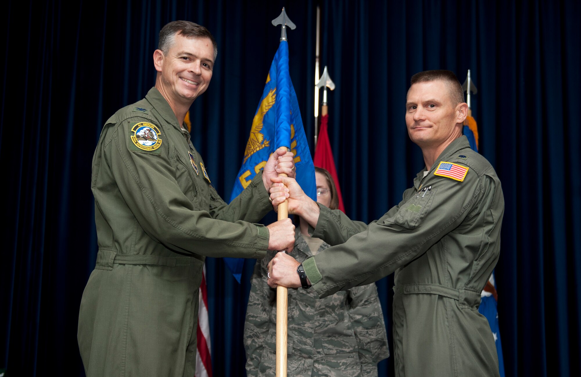 Lt. Col. Kevin Schiller, former 39th Expeditionary Operations Group commander, passes the 39th EOG guidon to Col. Craig Wills, 39th Air Base Wing commander, during a change of command ceremony Aug. 13, 2013, at Incirlik Air Base, Turkey. The symbolic gesture of passing the guidon was accomplished in front of the unit so that all could witness the new leader, Lt. Col. Christopher Voehl, assume command. (U.S. Air Force photo by Senior Airman Daniel Phelps/Released)