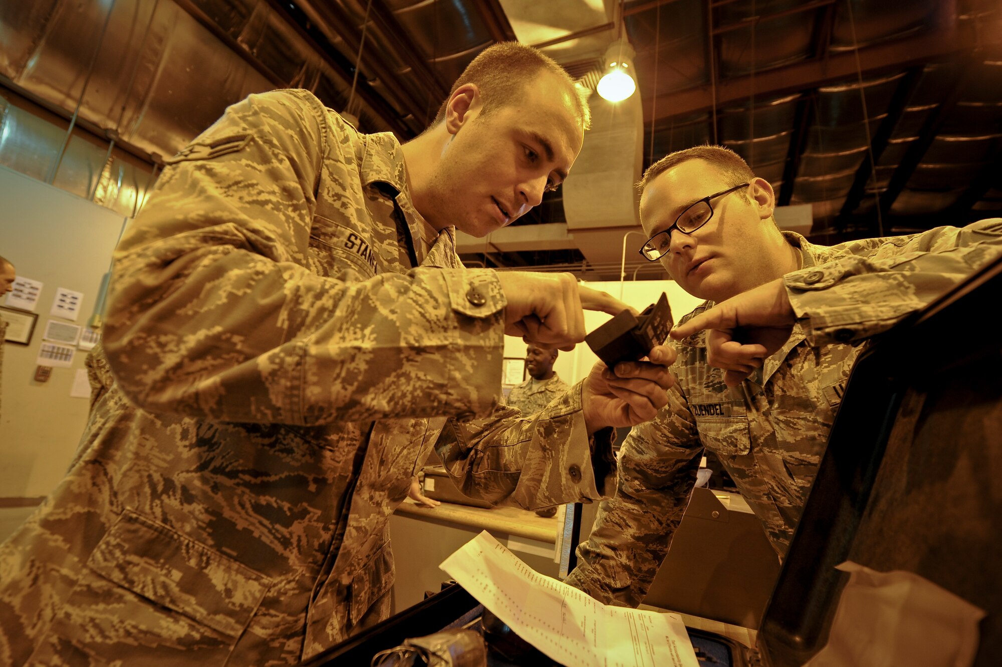 Airman 1st Class Steven Stanfa and Senior Airman Tim Zuendel inspect a tool's coding as Stanfa returns a tool kit to the consolidated tool kit at the 379th Air Expeditionary Wing in Southwest Asia, Aug. 8, 2013. Stanfa is an 8th Expeditionary Air Mobility Squadron CTK debriefer deployed from Joint Base Lewis-McChord, Wash., and hails from Rock Island, Tenn. Zuendel  is an 8th EAMS CTK custodian deployed from Travis Air Force Base, Calif., and hails from Maine, N.Y. (U.S. Air Force photo/Senior Airman Benjamin Stratton)