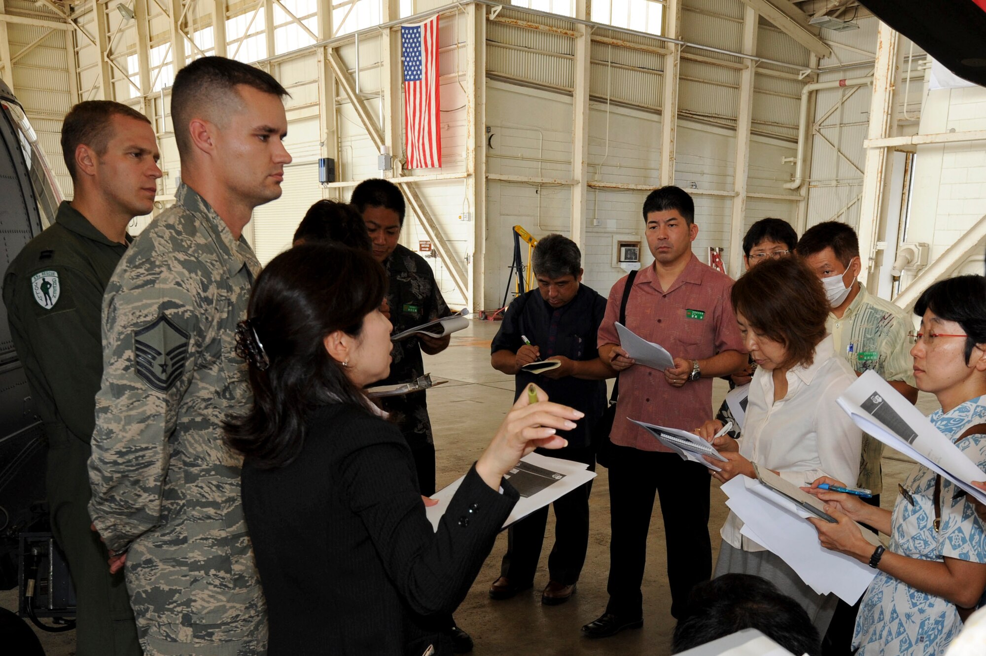Keiko Toma, 18th Wing community relations specialist, translates information about the HH-60G Pave Hawk to brief local media about the different components of the Pave Hawk during a media brief at Kadena Air Base, Japan, Aug. 14, 2013. U.S. Air Force Master Sgt. Ct Kirk, 718th Aircraft Maintenance Squadron 33rd Helicopter Maintenance Unit production superintendent, and Capt. Mike Kingry, 18th Wing chief of helicopter tactics, answered questions and explained the safety inspection to the local media during this inspection. (U.S. Air Force photo by Malia S. Jenkins/Released)