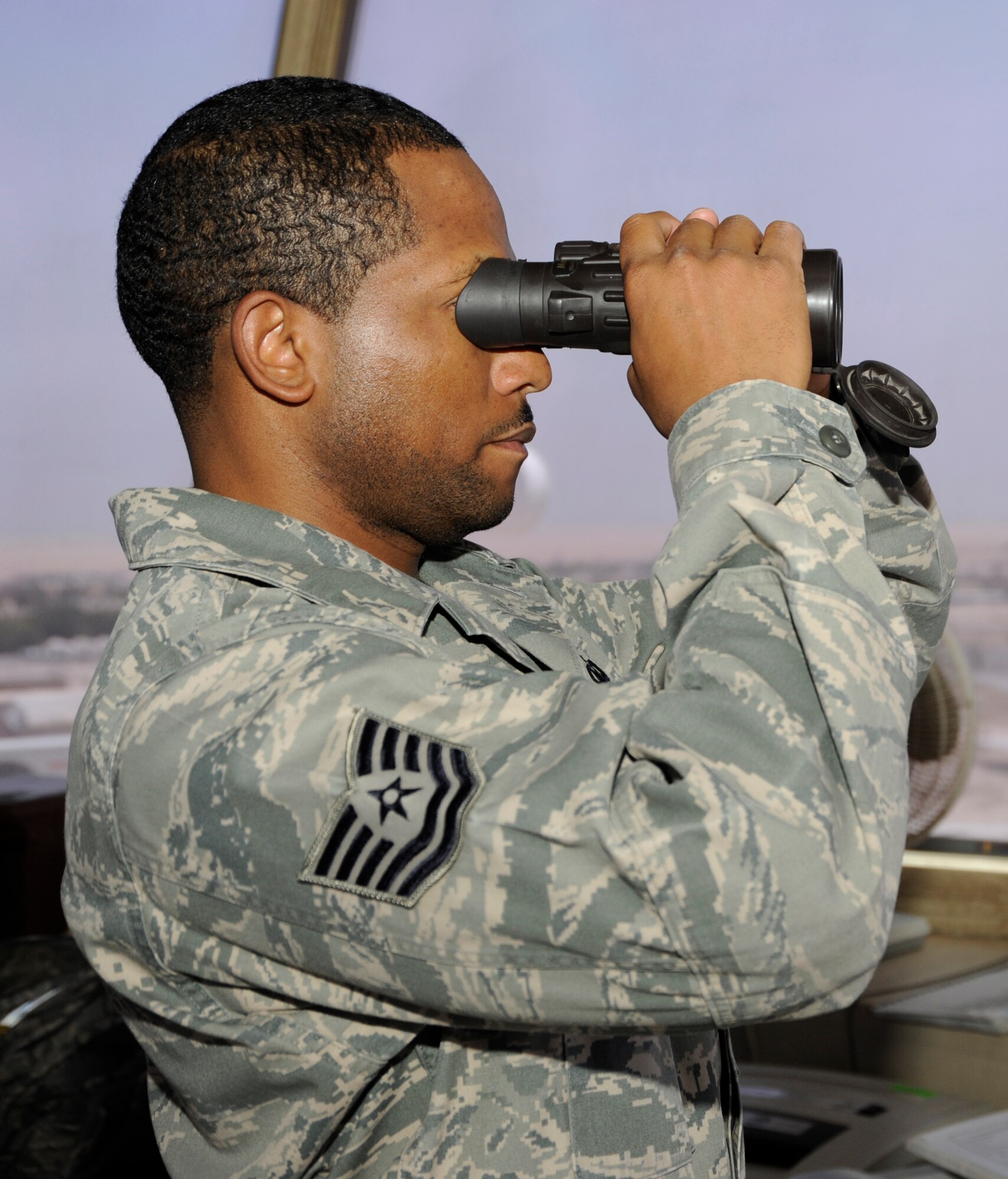 Tech. Sgt. Andre Perry, 386th Expeditionary Operations Support Squadron, air traffic control liaison officer, uses binoculars here, August 9, 2013.  Perry uses binoculars to ensure there are no foreign objects or animals on the landing strip prior to aircraft taking off or landing.  Perry, a native of Portsmouth Va., is deployed out of the 22nd Air Refueling Wing, McConnell Air Force Base, Kan. (U.S. Air Force photo by Master Sgt. Christopher A. Campbell)