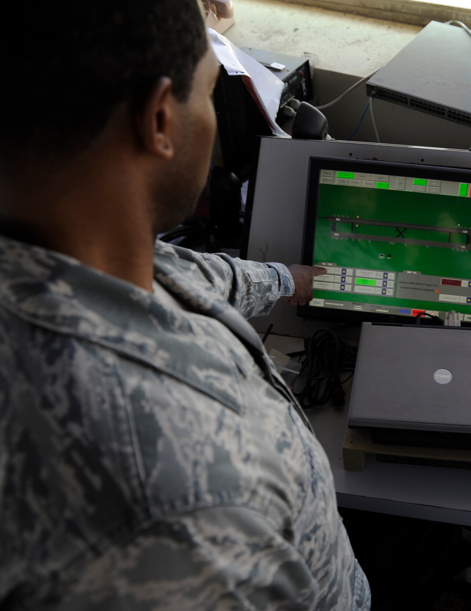 Tech. Sgt. Andre Perry, 386th Expeditionary Operations Support Squadron, air traffic control liaison officer, adjusts approach lighting intensities on the airfield lighting panel here, Aug. 9, 2013. The touch-screen panel adjusts runway approach lights, precision approach lights, taxiway lights and the airport beacon.  Perry, a native of Portsmouth, Va., is deployed out of the 22nd Air Refueling Wing, McConnell Air Force Base, Kan.  (U.S. Air Force photo by Master Sgt. Christopher A. Campbell)