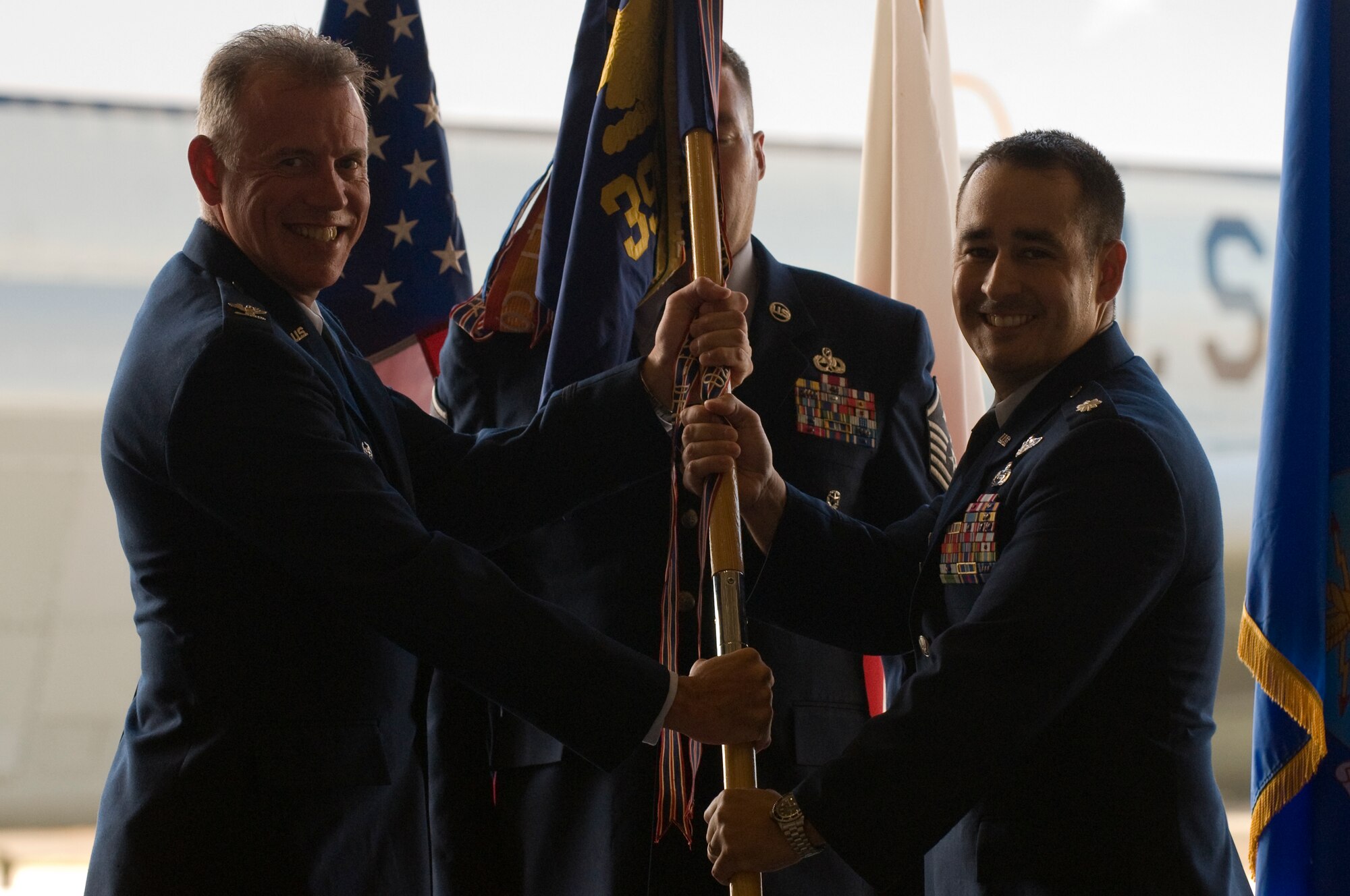 U.S. Air Force Col. Russell Mammoser, 55th Operations Group commander, Offutt Air Force Base, Neb., passes the command guidon to Lt. Col. Kouji Gillis, 390th Intelligence Squadron commander, during his change of command ceremony on Kadena Air Base, Japan, Aug. 14, 2013. Gillis comes from NATO Air Training Command-Afghanistan, where he served as commander’s action group director and lead strategist. (U.S. Air Force photo by Senior Airman Marcus Morris/Released) 