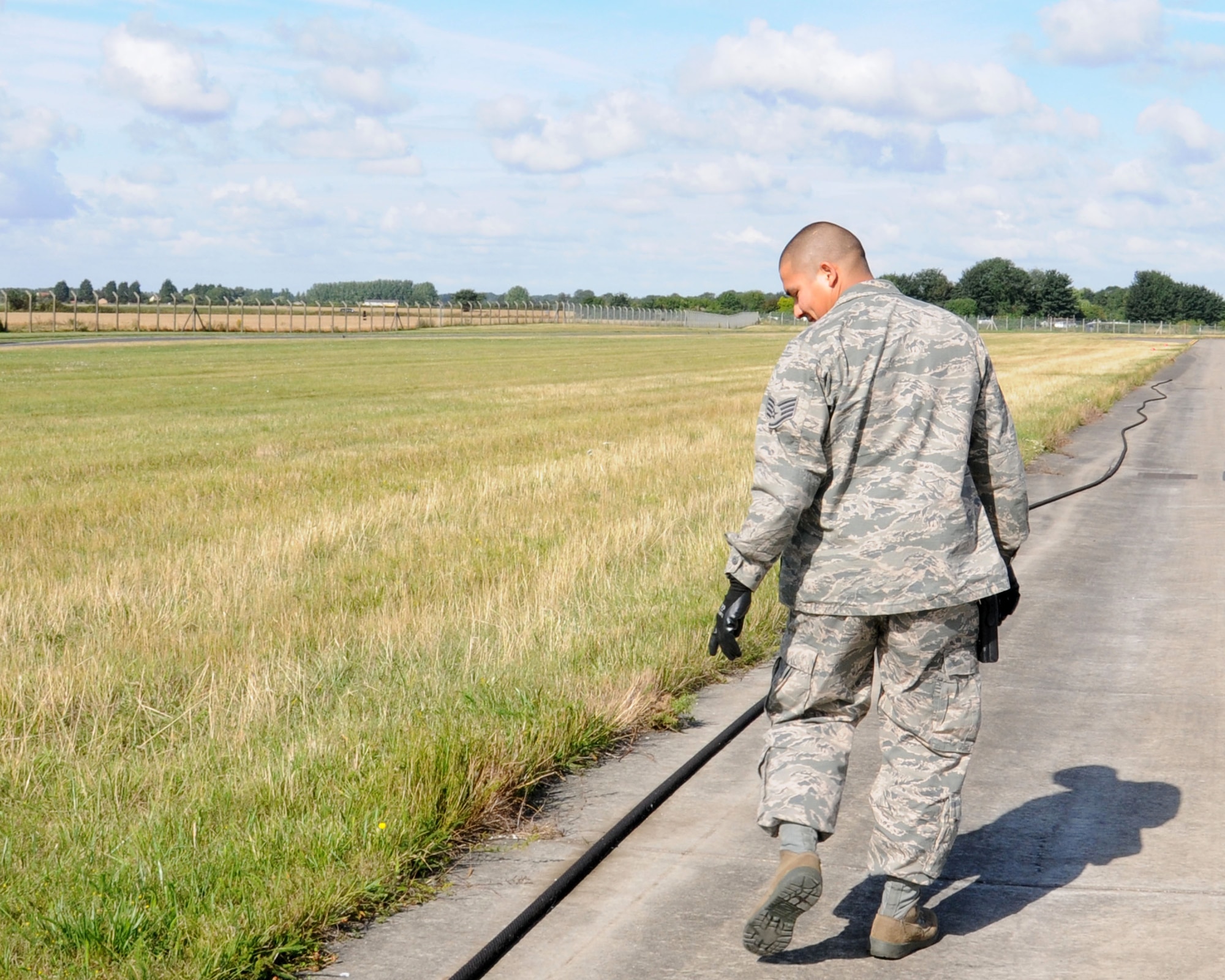 U.S. Air Force Staff Sgt. Jose Vargas, 100th Civil Engineer Squadron Electrical Power Production journeyman from El Paso, Texas, checks the line on a textile barrier on the runway Aug. 13, 2013, on RAF Mildenhall, England. The barrier is checked daily for damage and its position. The shop maintains two textile aircraft arresting systems on base which are used in the event of an emergency landing. (U.S. Air Force photo by Gina Randall/Released)