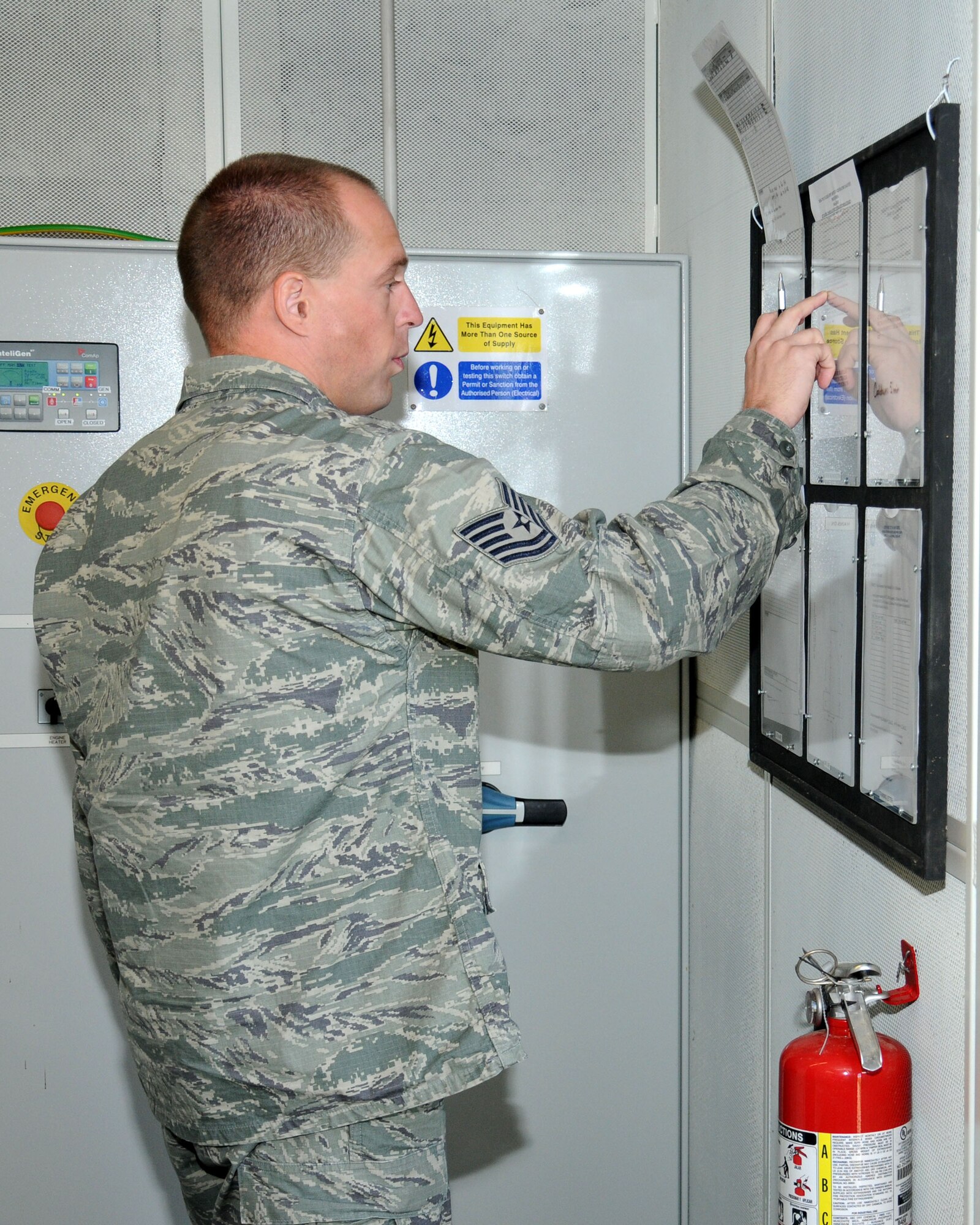 U.S. Air Force Tech. Sgt. Marc Bakker, 100th Civil Engineer Squadron Electrical Power Production craftsman from Grand Rapids, Mich., checks the paperwork to conduct an inspection performed every two weeks on a generator Aug. 13, 2013, on RAF Mildenhall, England. The shop has eight assigned personnel ensuring inspections are carried out regularly. During the inspections, service members must ensure personnel use the correct checklists. (U.S. Air Force photo by Gina Randall/Released)