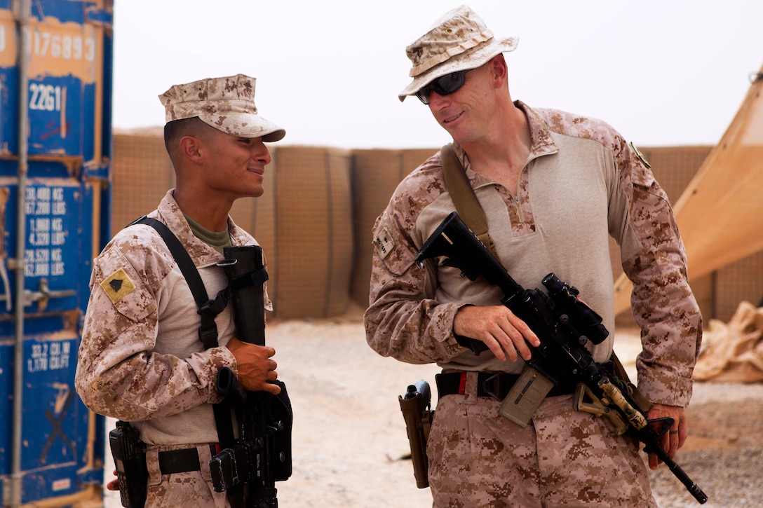 U.S. Marine Corps Sgt. Maj. Roger Griffith, right, speaks with U.S. Marine Corps Sgt. Juan Maravilla, left, during a visit on Camp Dwyer in Helmand province, Afghanistan, Aug. 7, 2013. Griffith is assigned to Combat Logistics Regiment 2, Regional Command Southwest, and Maravilla, a water purification specialist, is assigned to Engineer Company, Combat Logistics Regiment 2.