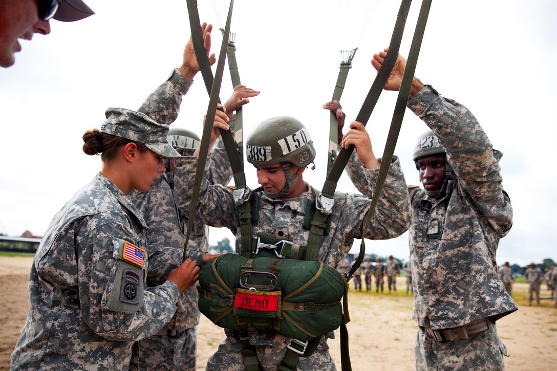 Army Cadet Michael Suarez gets hooked up before being hoisted to the top of a 250-foot tower during training at U.S. Army Airborne School on Fort Benning, Ga., Aug. 7, 2013. Suarez is a student attending Valley Forge Military College. The course includes three phases: ground week, tower week and jump week.