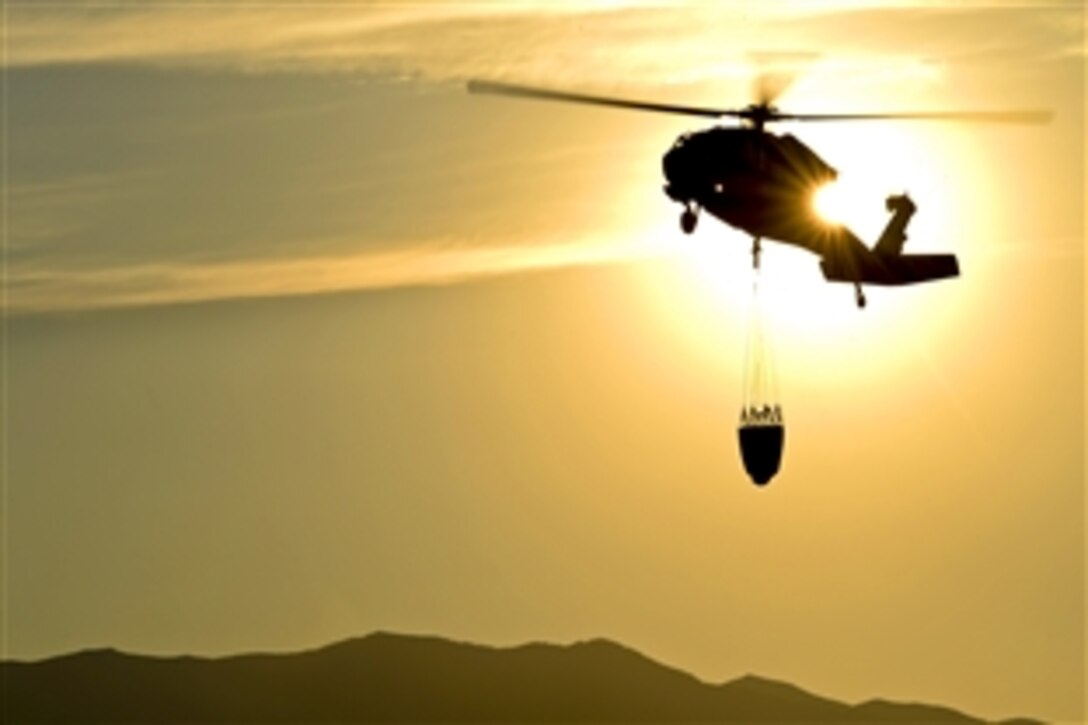 Soldiers in a UH-60 Black Hawk helicopter drop more than 8,500 gallons of water on two separate fires as they assist in fighting the fires in northern Utah, Aug. 12, 2013. The soldiers are assigned to the Utah Army National Guard's 2nd Battalion, 211th Aviation Regiment.
