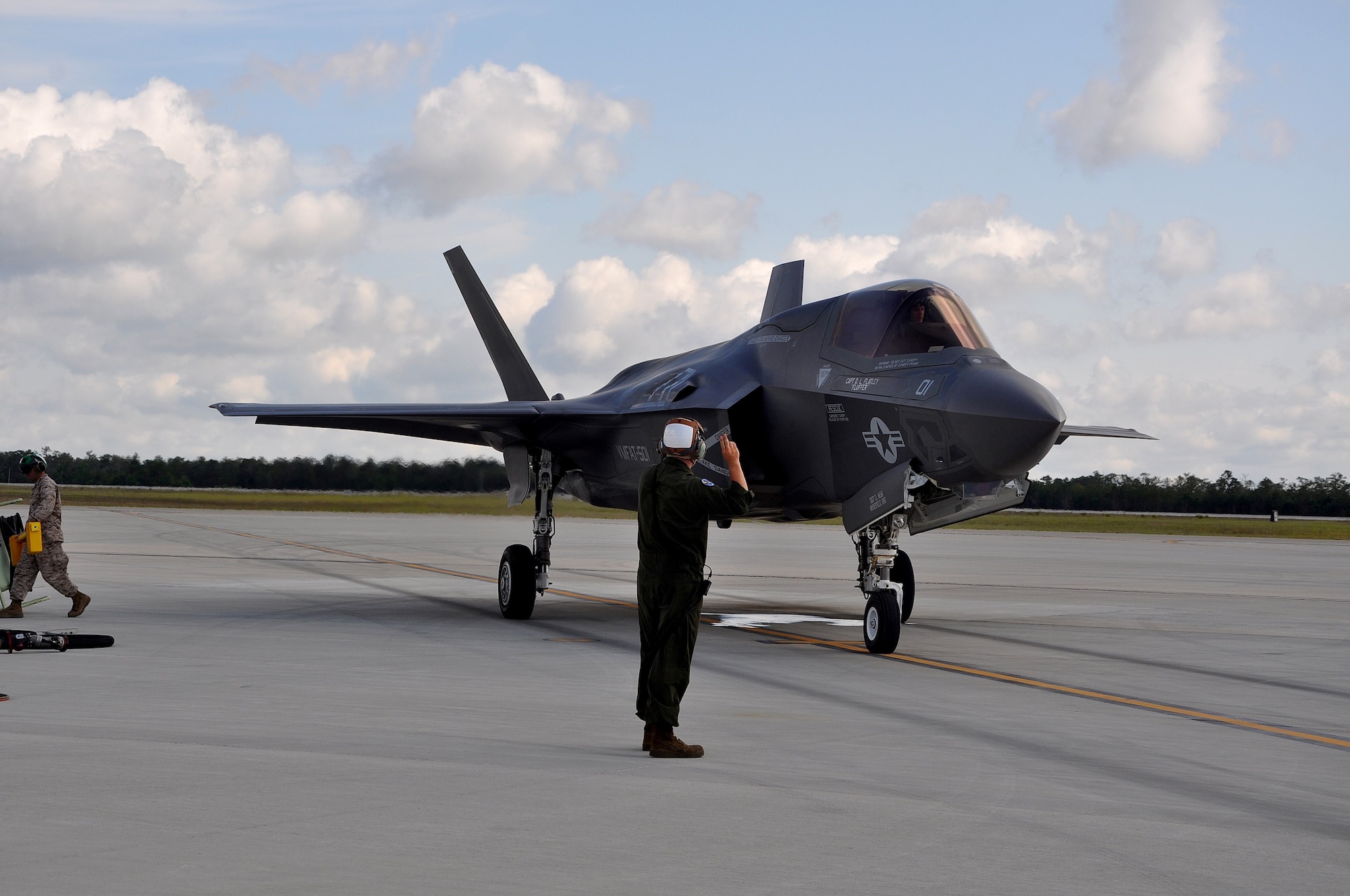 A U.S. Marine Corps plane captain, known as a crew chief in the Air Force, marshals out an F-35B Lightning II short takeoff and vertical landing variant of the aircraft May 22, 2013, at Eglin Air Force Base. The maintainer orchestrated a "hot pit" ground refueling, running the engine while receiving fuel, allowing it to take off immediately afterward for another training sortie. Assigned to the Marine Fighter Attack Training Squadron-501, the plane captain helped train up 24 U.S. and United Kingdom pilots flying the B variant to date by having aircraft ready for the daily flight operations. 