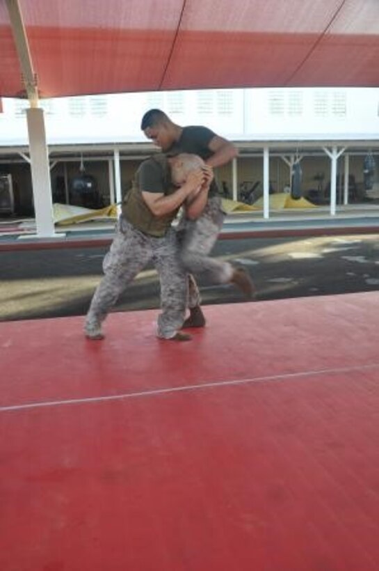 Sergeant Julio Acevedo, (left) the noncommissioned officer in charge of the administration office on Marine Corp Logistics Base Barstow and Lance Cpl. Jonathan Norita, a supply clerk on base practice knee strikes during a MCMAP class, July 22.


