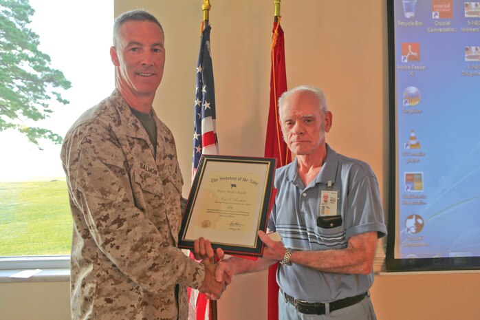 Col. Timothy M. Salmon, Marine Corps Air Station New River commanding officer presents an award for more than 50 years of service to Terry Trenchard, air station supply technician, during a civilian breakfast and award ceremony at the Officers Club, Aug. 7. 